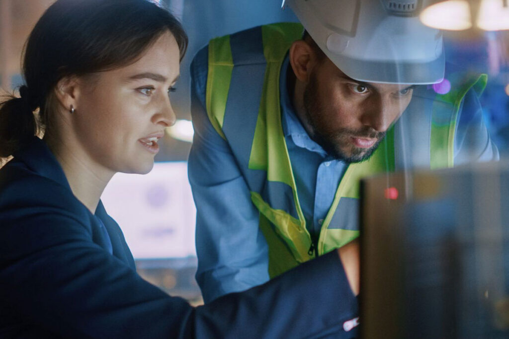 Workers at a computer in a manufacturing environment implementing OT security services