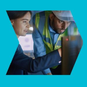 Workers at a computer in a manufacturing environment implementing OT security services