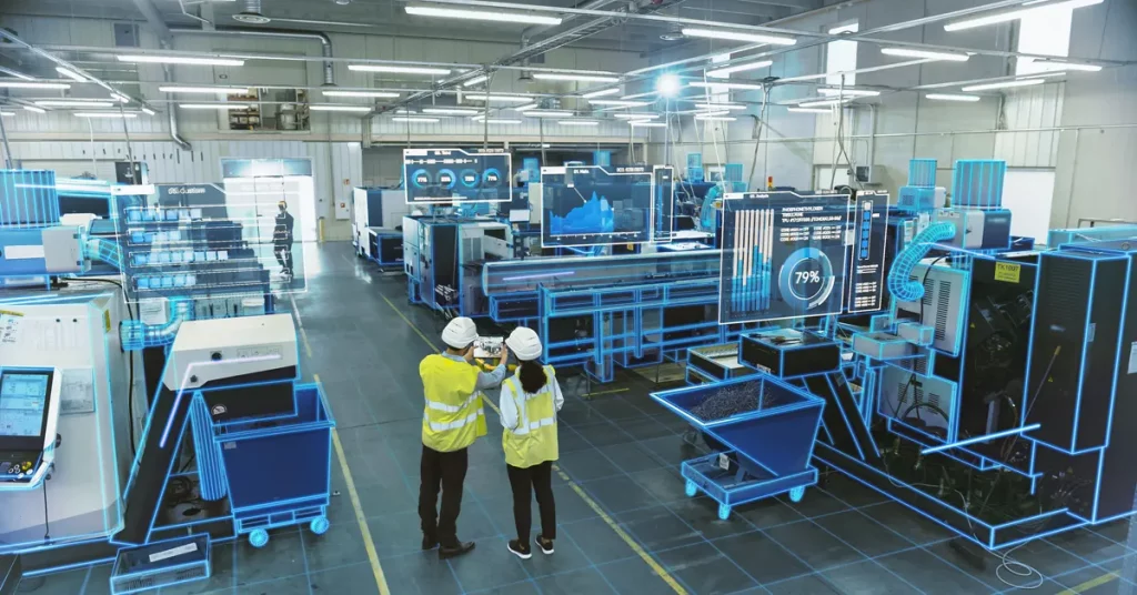 Two workers in hi visibility jackets seen from a distance standing on a factory floor